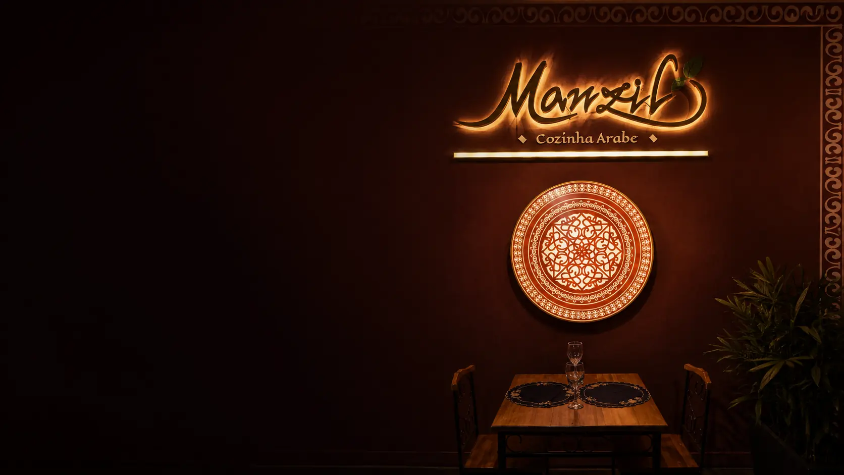 Salão do Manzil Cozinha Árabe em Brasília, com letreiro iluminado, prato árabe decorativo e mesa posta